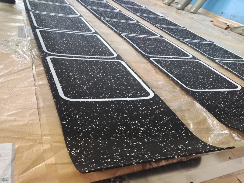 An engineering diagram showing impact force dissipating through layers of rubber flooring into a concrete subfloor.